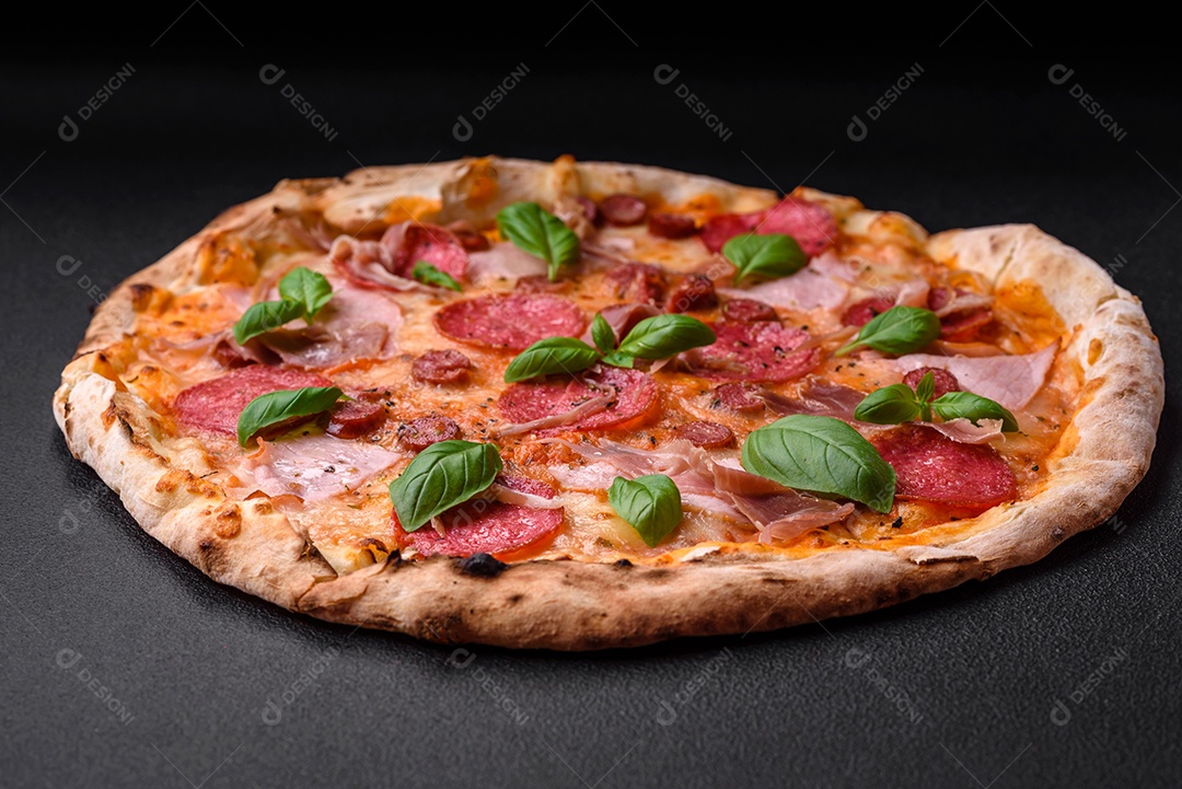 Deliciosa pizza assada em forno fresco com salame, carne, queijo, tomate, especiarias e ervas sobre um fundo escuro de concreto