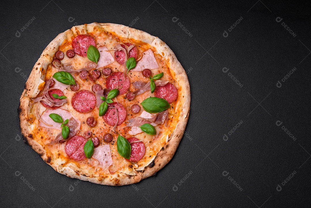 Deliciosa pizza assada em forno fresco com salame, carne, queijo, tomate, especiarias e ervas sobre um fundo escuro de concreto