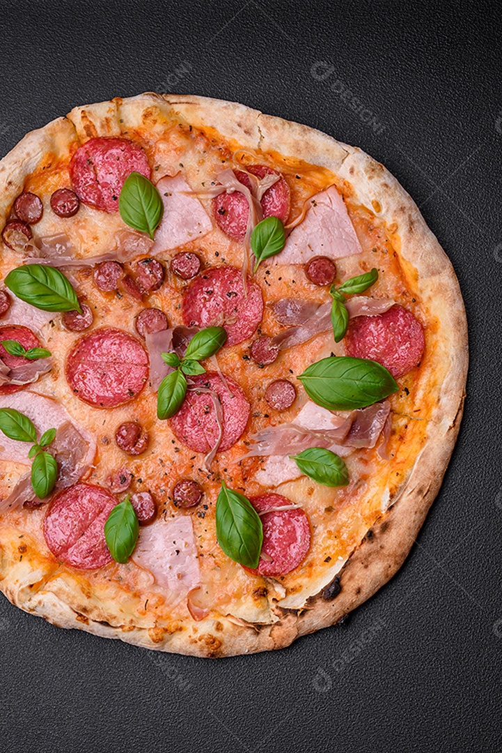 Deliciosa pizza assada em forno fresco com salame, carne, queijo, tomate, especiarias e ervas sobre um fundo escuro de concreto