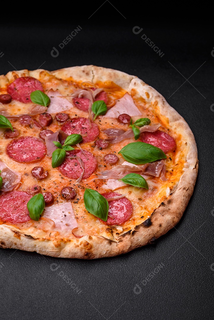 Deliciosa pizza assada em forno fresco com salame, carne, queijo, tomate, especiarias e ervas sobre um fundo escuro de concreto