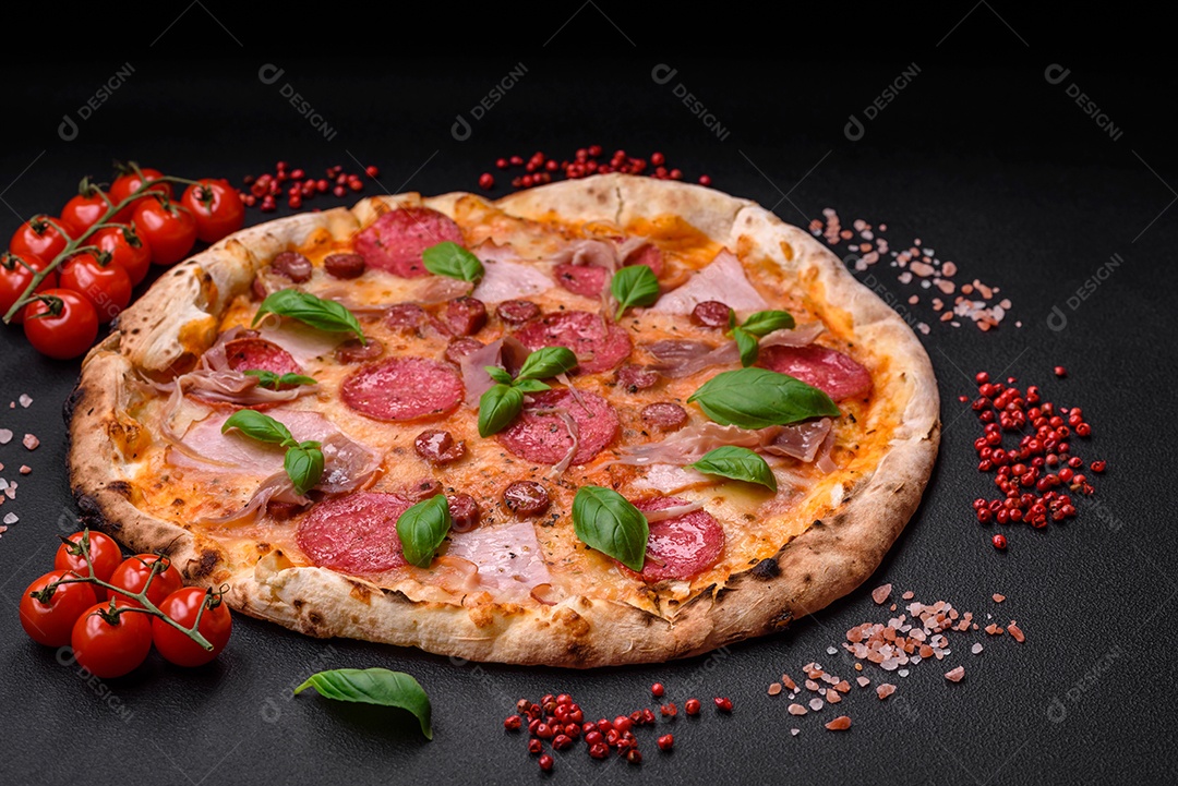 Deliciosa pizza assada em forno fresco com salame, carne, queijo, tomate, especiarias e ervas sobre um fundo escuro de concreto