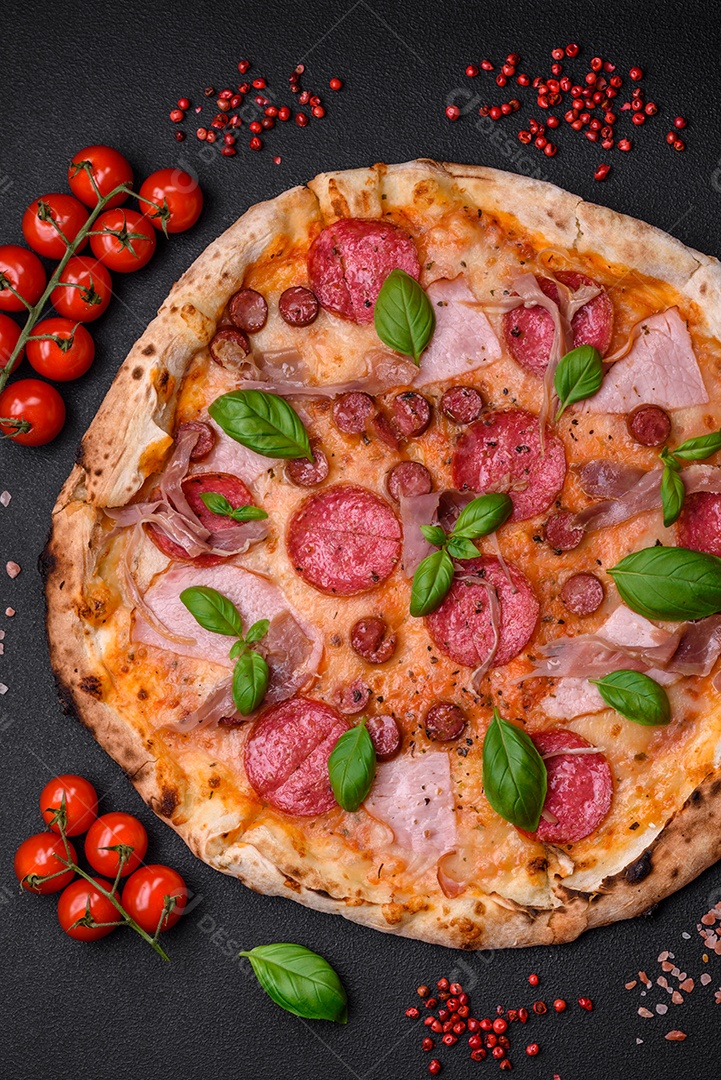 Deliciosa pizza assada em forno fresco com salame, carne, queijo, tomate, especiarias e ervas sobre um fundo escuro de concreto
