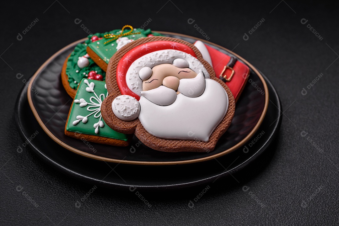 Lindos biscoitos de gengibre caseiros coloridos de Natal ou Ano Novo sobre um fundo escuro de concreto
