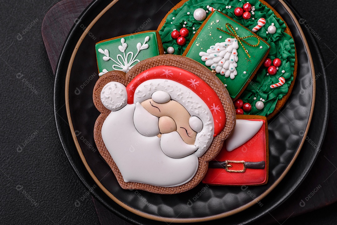 Lindos biscoitos de gengibre caseiros coloridos de Natal ou Ano Novo sobre um fundo escuro de concreto