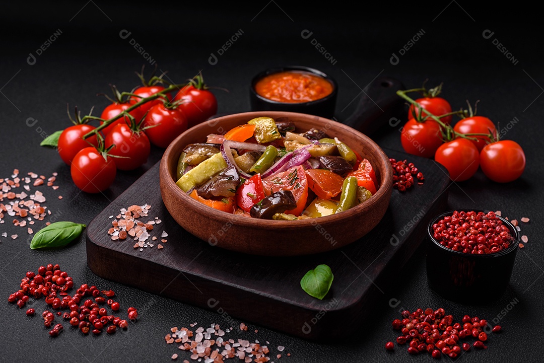 Deliciosa salada vegetariana fresca com tomate, feijão verde, berinjela, pimenta, sal, especiarias e ervas sobre um fundo escuro de concreto