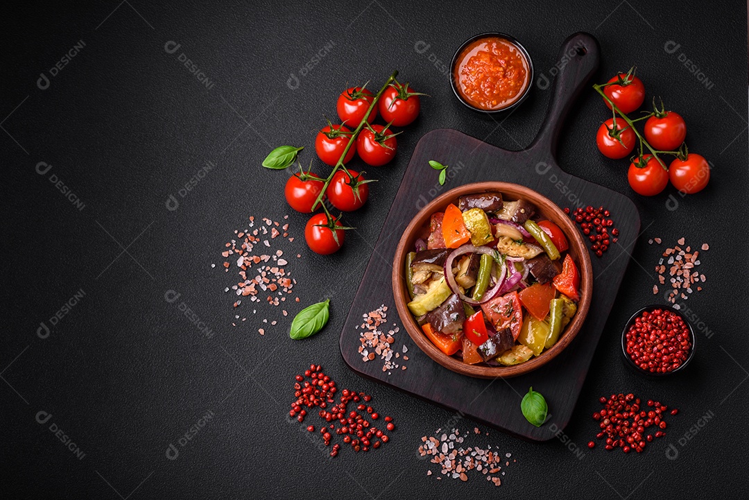 Deliciosa salada vegetariana fresca com tomate, feijão verde, berinjela, pimenta, sal, especiarias e ervas sobre um fundo escuro de concreto