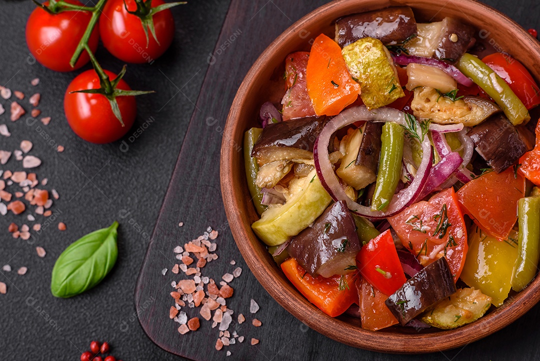 Deliciosa salada vegetariana fresca com tomate, feijão verde, berinjela, pimenta, sal, especiarias e ervas sobre um fundo escuro de concreto