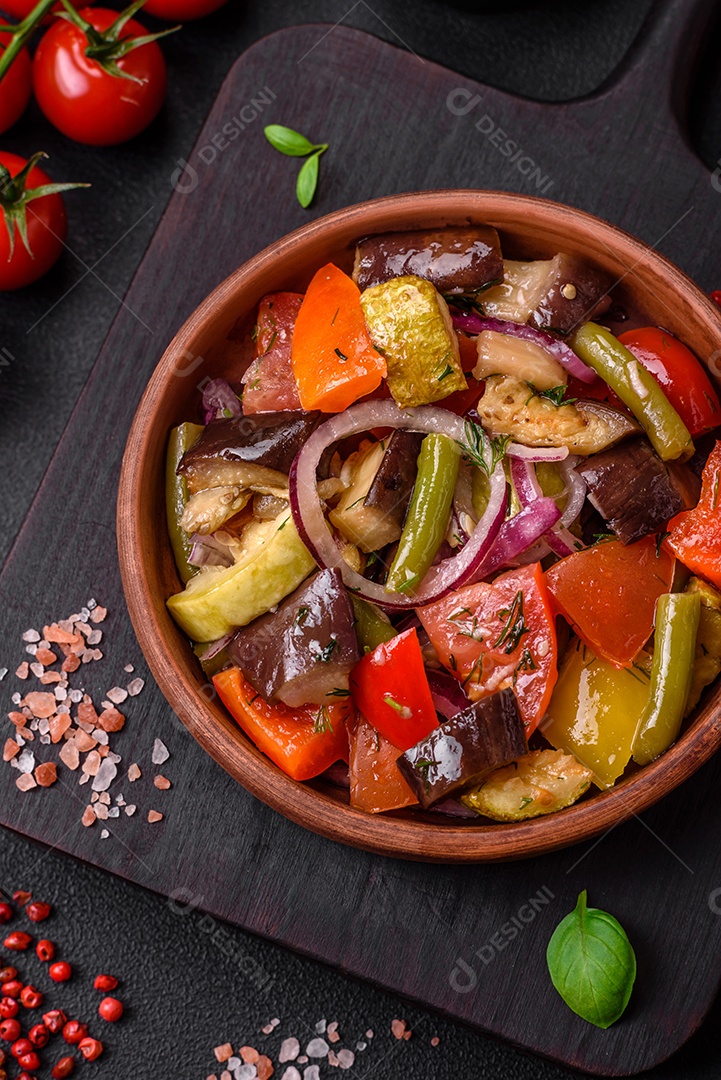 Deliciosa salada vegetariana fresca com tomate, feijão verde, berinjela, pimenta, sal, especiarias e ervas sobre um fundo escuro de concreto