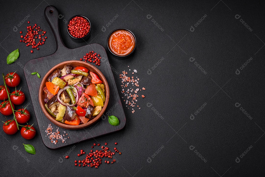 Deliciosa salada vegetariana fresca com tomate, feijão verde, berinjela, pimenta, sal, especiarias e ervas sobre um fundo escuro de concreto