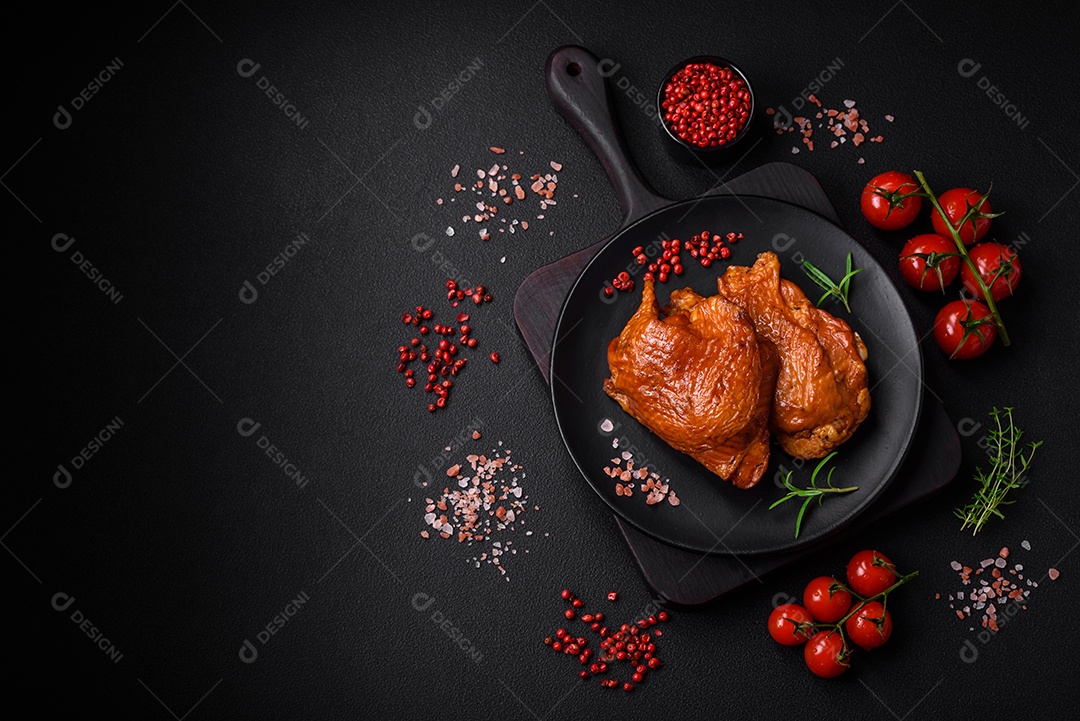 Deliciosas coxas de frango frito ou defumado grelhadas com especiarias e ervas sobre fundo escuro de concreto