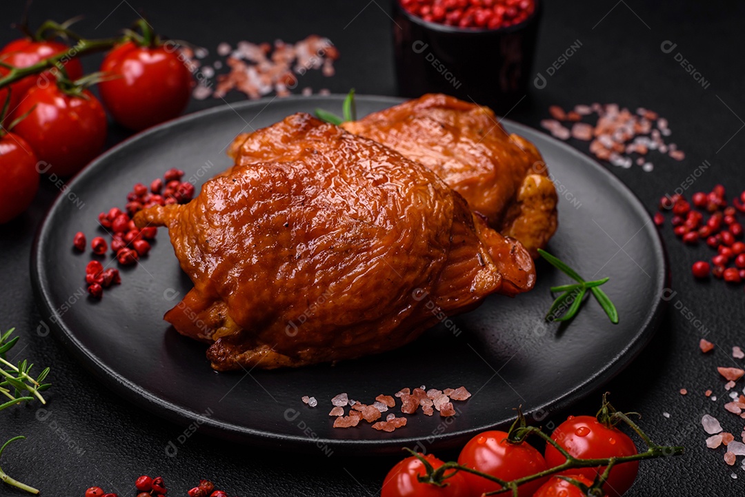 Deliciosas coxas de frango frito ou defumado grelhadas com especiarias e ervas sobre fundo escuro de concreto
