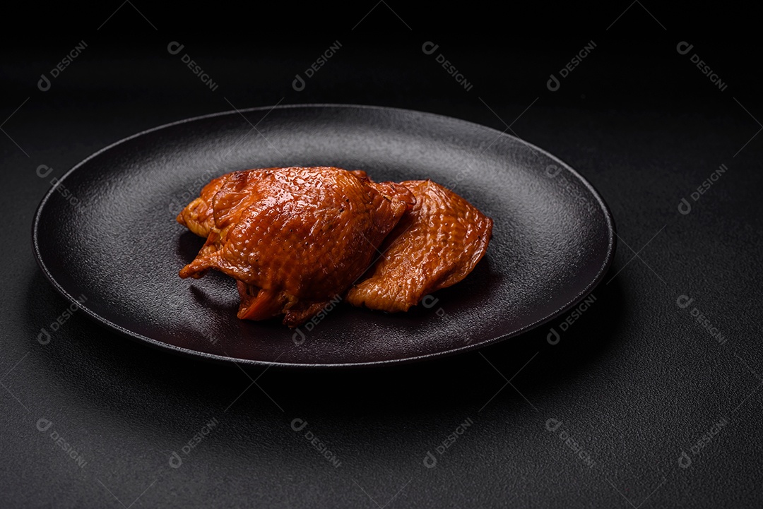 Deliciosas coxas de frango frito ou defumado grelhadas com especiarias e ervas sobre fundo escuro de concreto