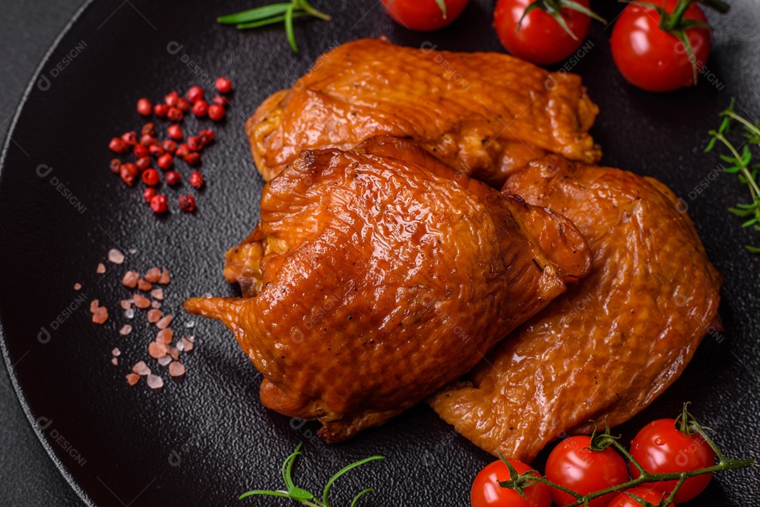 Deliciosas coxas de frango frito ou defumado grelhadas com especiarias e ervas sobre fundo escuro de concreto