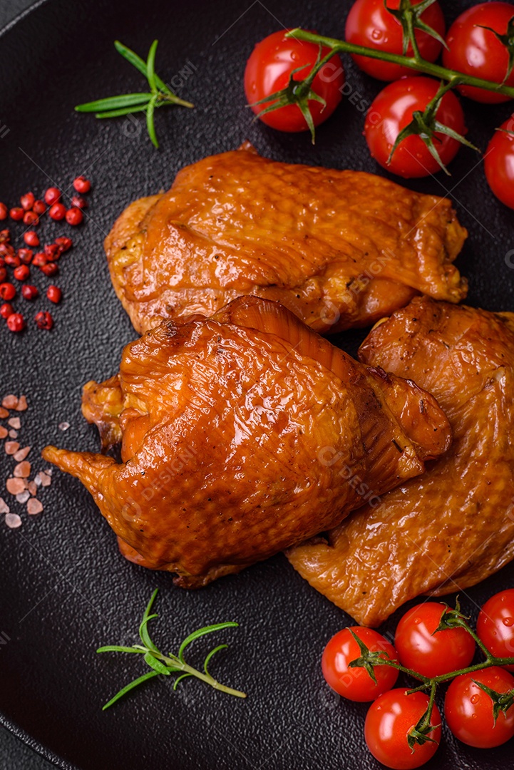 Deliciosas coxas de frango frito ou defumado grelhadas com especiarias e ervas sobre fundo escuro de concreto