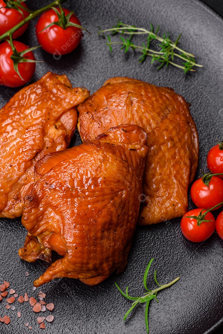 Deliciosas coxas de frango frito ou defumado grelhadas com especiarias e ervas sobre fundo escuro de concreto