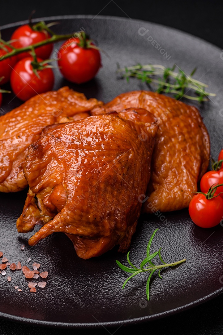 Deliciosas coxas de frango frito ou defumado grelhadas com especiarias e ervas sobre fundo escuro de concreto