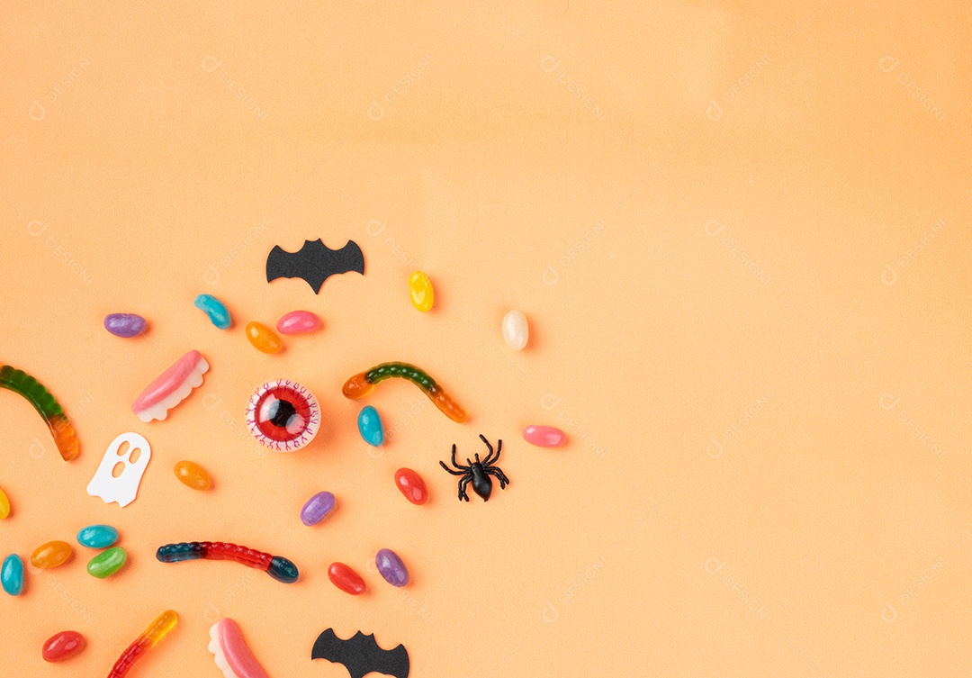 Doces coloridos sobre fundo laranja com espaço de cópia.