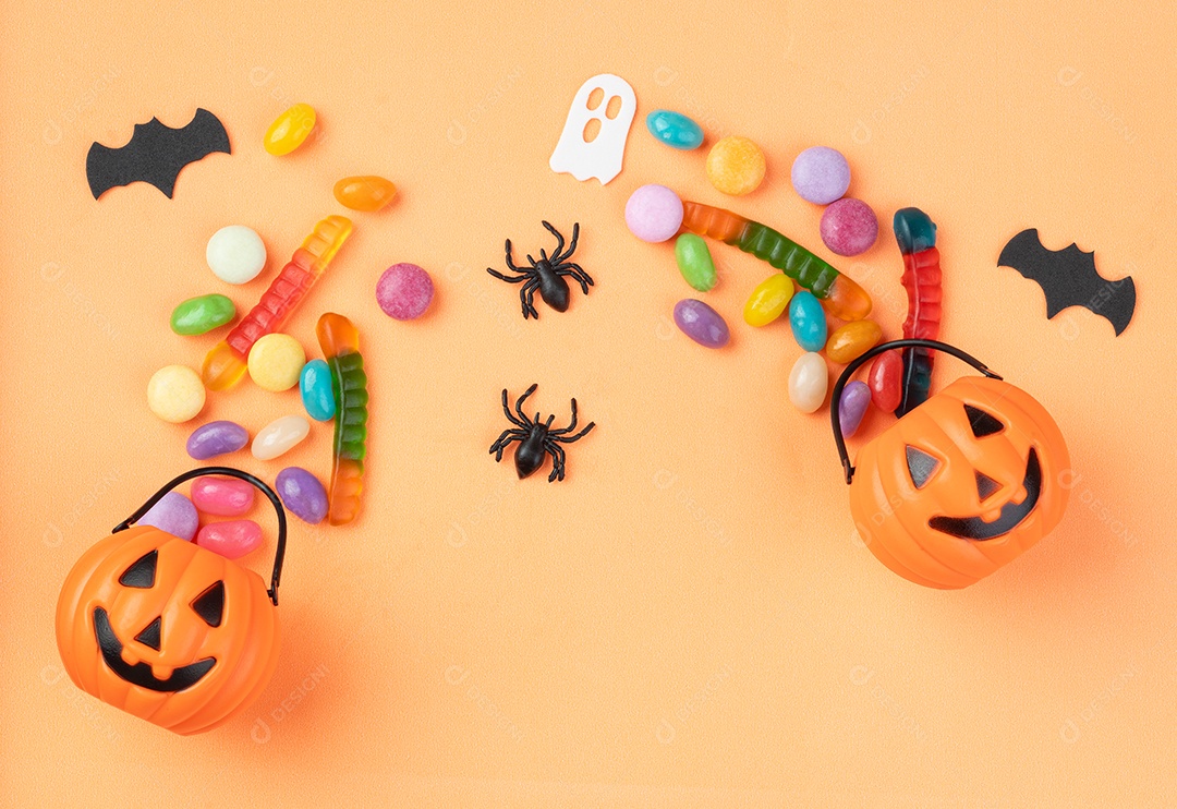 Doces coloridos variados sobre fundo laranja.