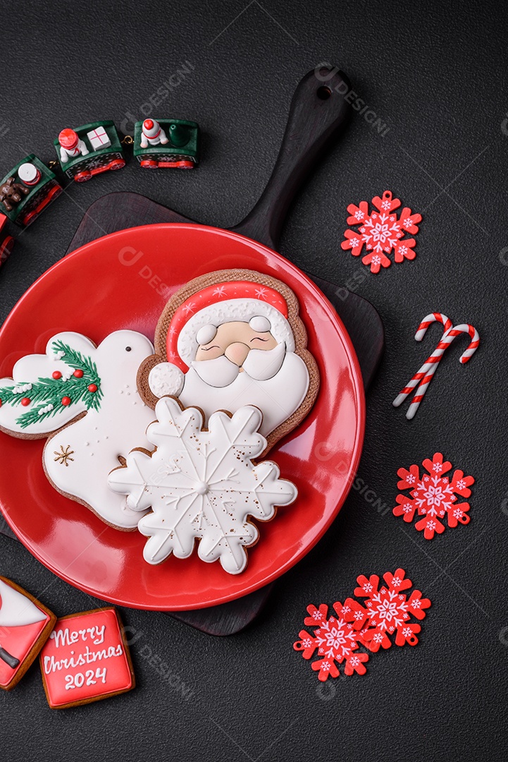 Lindos biscoitos de gengibre caseiros coloridos e brilhantes em uma placa de cerâmica sobre um fundo escuro de concreto