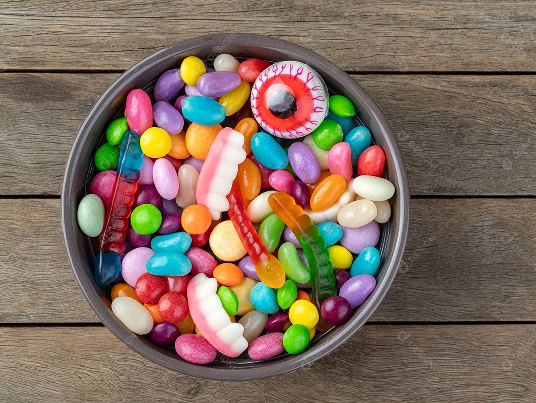 Doces coloridos sobre fundo laranja com espaço de cópia.