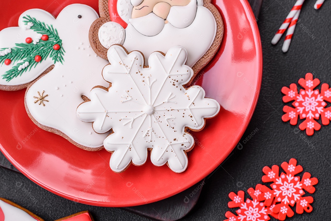 Lindos biscoitos de gengibre caseiros coloridos e brilhantes em uma placa de cerâmica sobre um fundo escuro de concreto