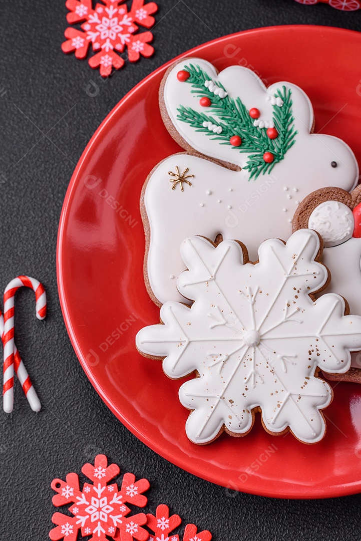 Lindos biscoitos de gengibre caseiros coloridos e brilhantes em uma placa de cerâmica sobre um fundo escuro de concreto