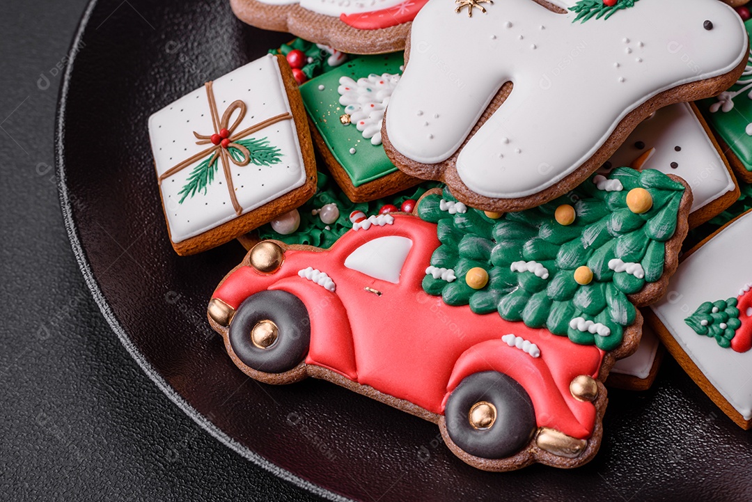 Lindos biscoitos de gengibre caseiros coloridos e brilhantes em uma placa de cerâmica sobre um fundo escuro de concreto