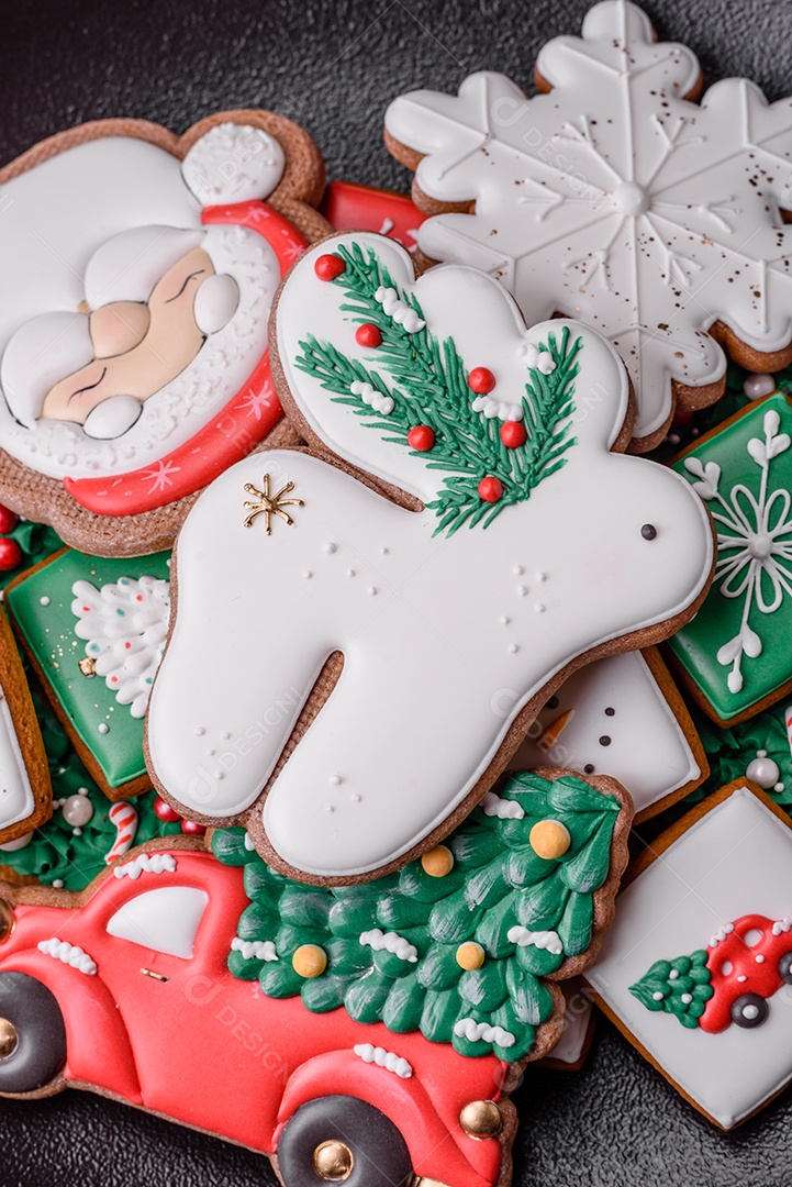 Lindos biscoitos de gengibre caseiros coloridos e brilhantes em uma placa de cerâmica sobre um fundo escuro de concreto