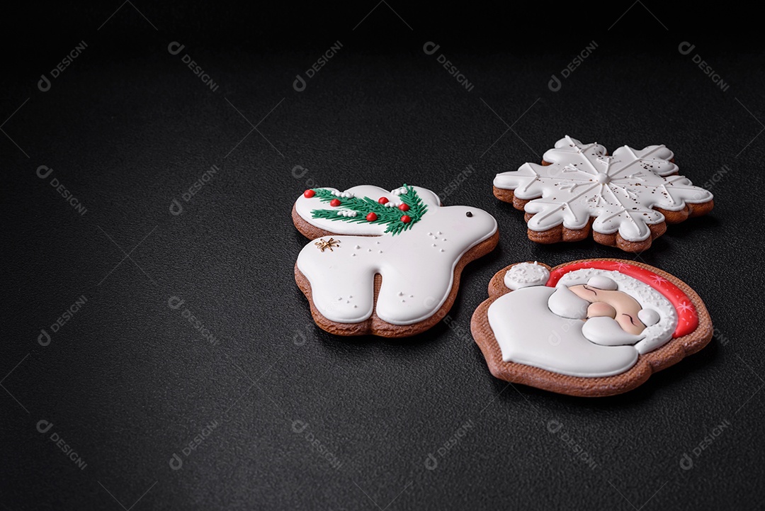 Lindos biscoitos de gengibre caseiros coloridos e brilhantes em uma placa de cerâmica sobre um fundo escuro de concreto