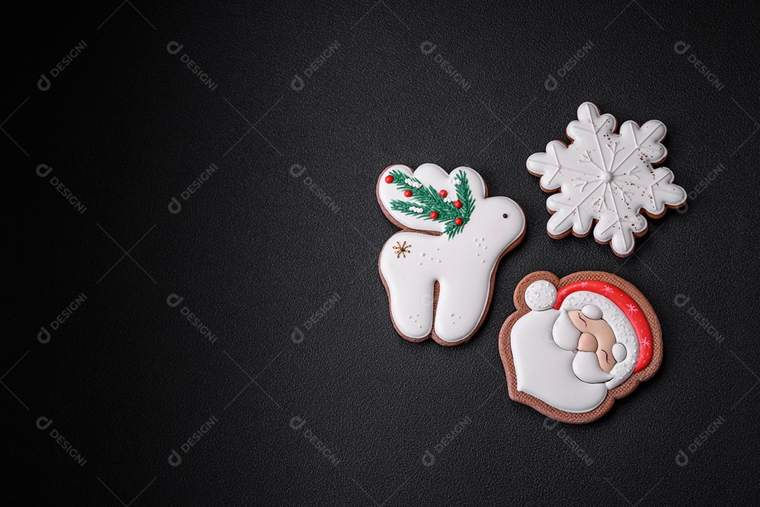 Lindos biscoitos de gengibre caseiros coloridos e brilhantes em uma placa de cerâmica sobre um fundo escuro de concreto