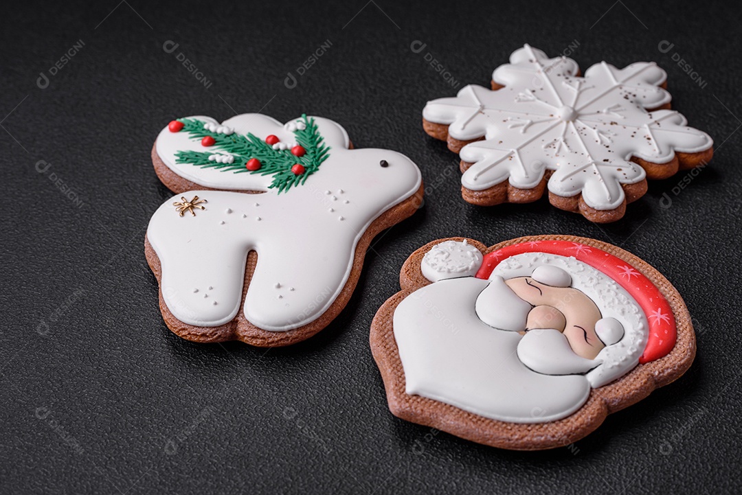 Lindos biscoitos de gengibre caseiros coloridos e brilhantes em uma placa de cerâmica sobre um fundo escuro de concreto