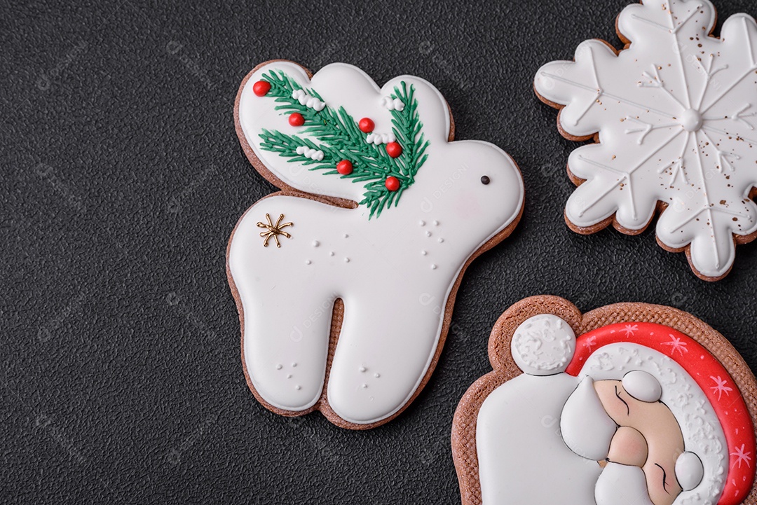 Lindos biscoitos de gengibre caseiros coloridos e brilhantes em uma placa de cerâmica sobre um fundo escuro de concreto