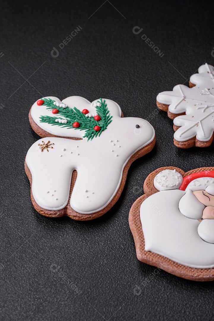 Lindos biscoitos de gengibre caseiros coloridos e brilhantes em uma placa de cerâmica sobre um fundo escuro de concreto