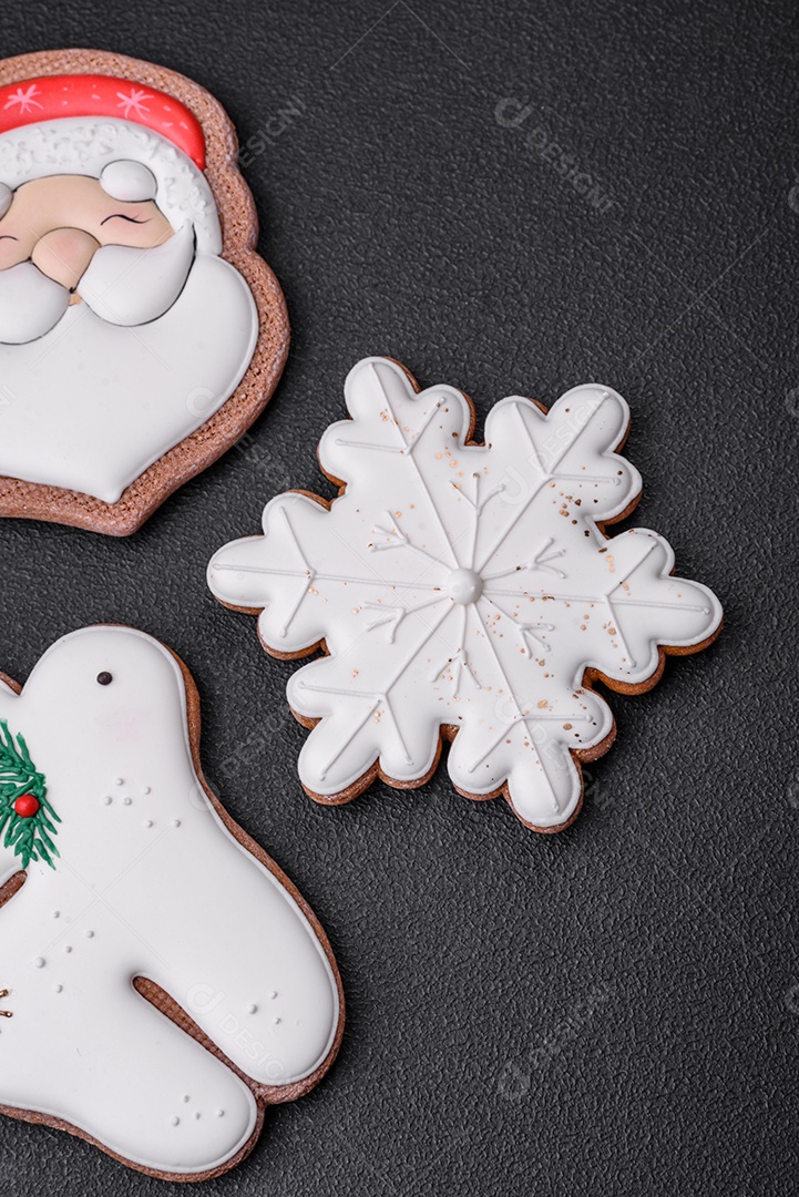 Lindos biscoitos de gengibre caseiros coloridos e brilhantes em uma placa de cerâmica sobre um fundo escuro de concreto