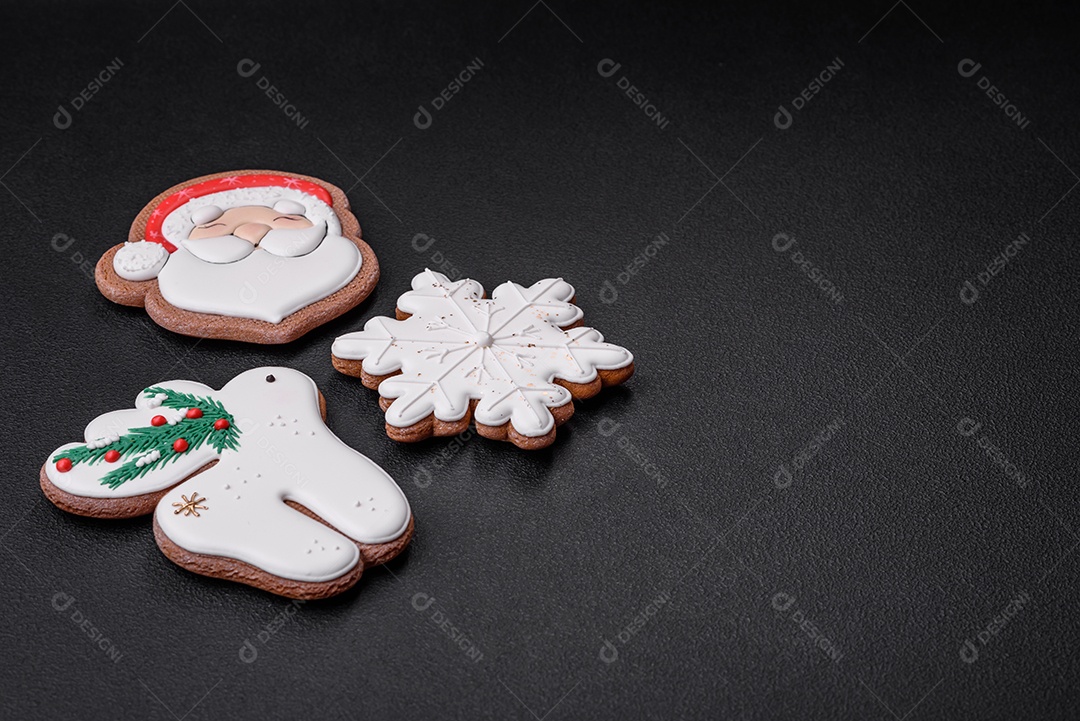 Lindos biscoitos de gengibre caseiros coloridos e brilhantes em uma placa de cerâmica sobre um fundo escuro de concreto