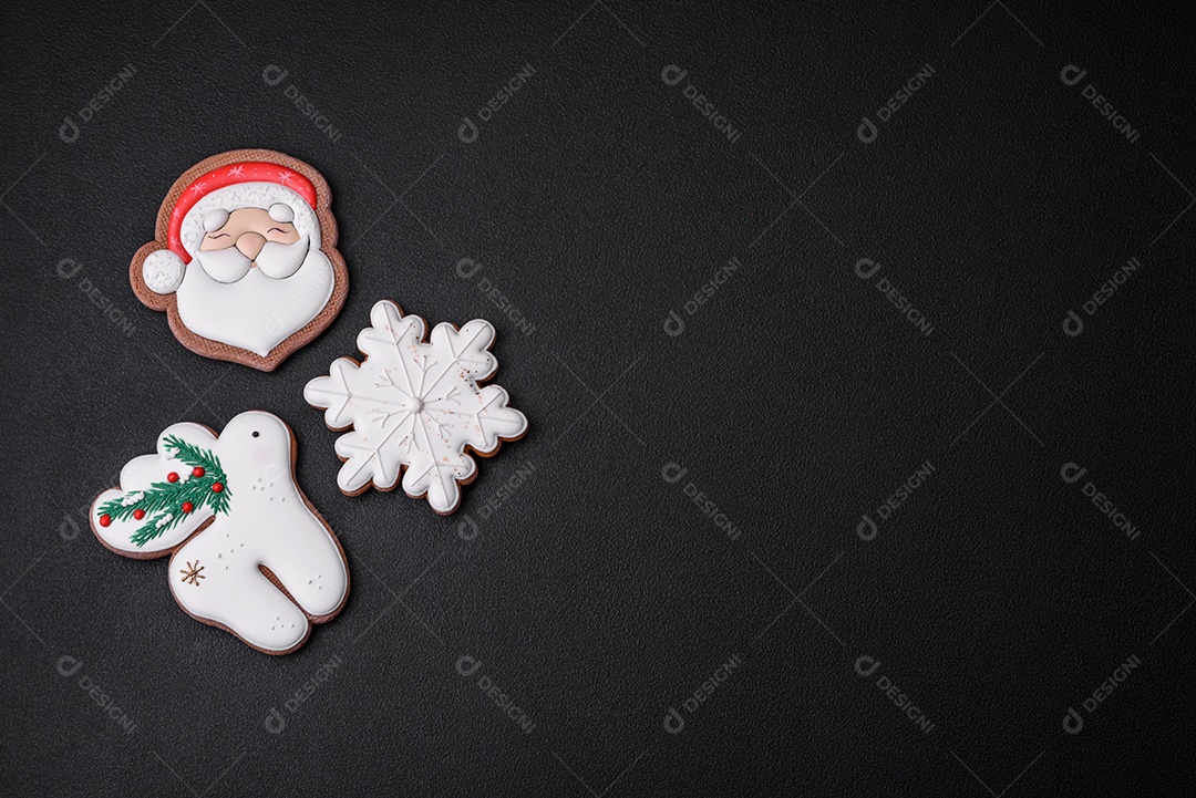 Lindos biscoitos de gengibre caseiros coloridos e brilhantes em uma placa de cerâmica sobre um fundo escuro de concreto