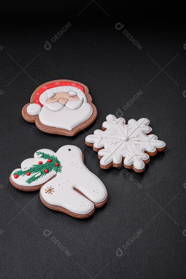 Lindos biscoitos de gengibre caseiros coloridos e brilhantes em uma placa de cerâmica sobre um fundo escuro de concreto