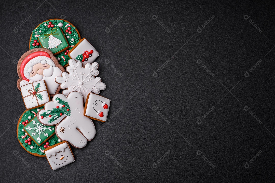 Lindos biscoitos de gengibre caseiros coloridos e brilhantes em uma placa de cerâmica sobre um fundo escuro de concreto