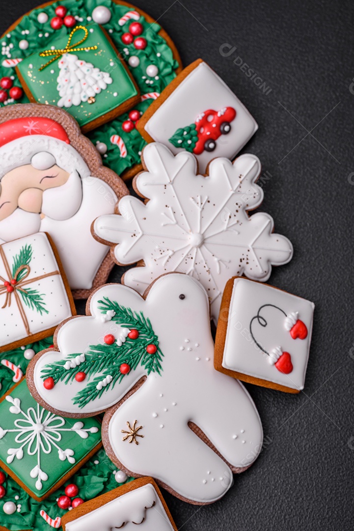 Lindos biscoitos de gengibre caseiros coloridos e brilhantes em uma placa de cerâmica sobre um fundo escuro de concreto