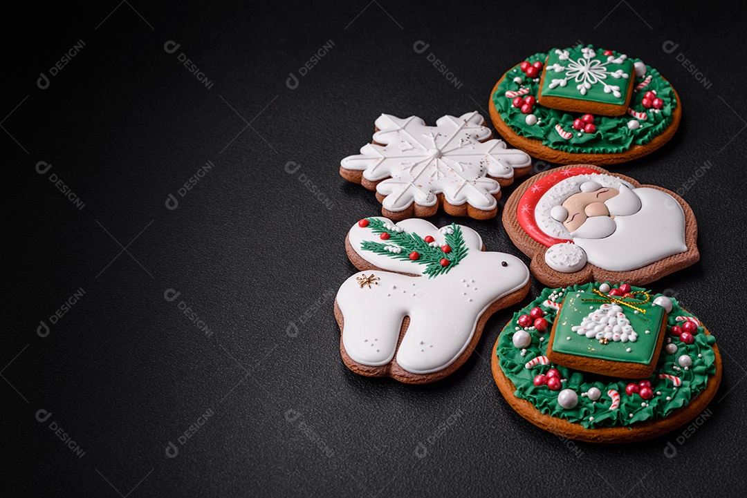 Lindos biscoitos de gengibre caseiros coloridos e brilhantes em uma placa de cerâmica sobre um fundo escuro de concreto