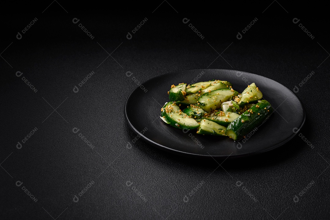 Delicioso pepino suculento cortado em grandes fatias com sal, especiarias e mostarda francesa sobre um fundo escuro de concreto