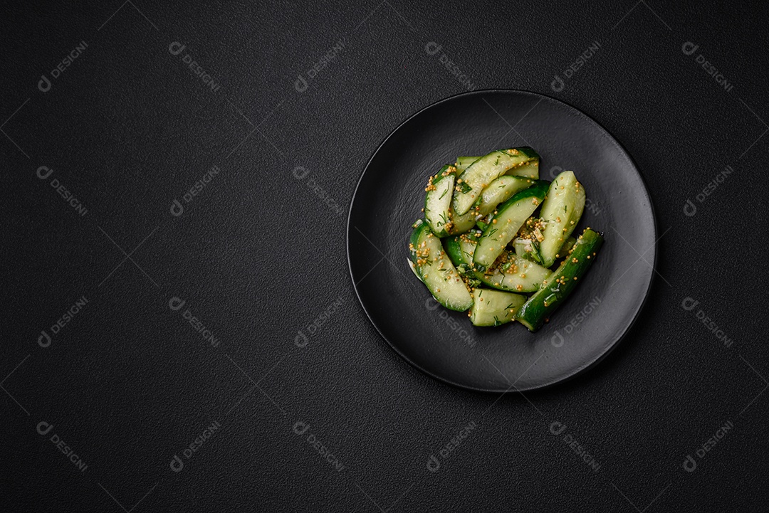 Delicioso pepino suculento cortado em grandes fatias com sal, especiarias e mostarda francesa sobre um fundo escuro de concreto