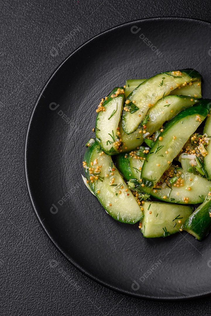 Delicioso pepino suculento cortado em grandes fatias com sal, especiarias e mostarda francesa sobre um fundo escuro de concreto