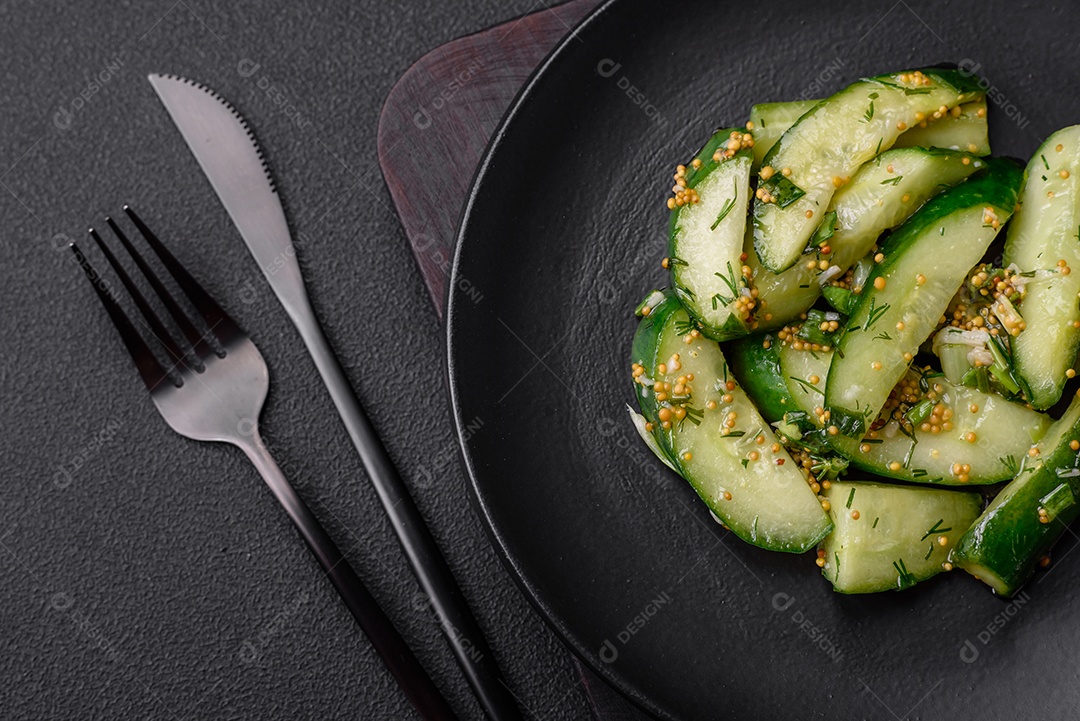 Delicioso pepino suculento cortado em grandes fatias com sal, especiarias e mostarda francesa sobre um fundo escuro de concreto
