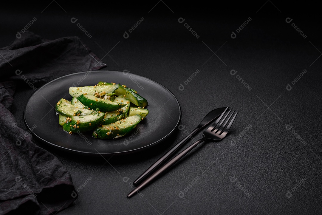 Delicioso pepino suculento cortado em grandes fatias com sal, especiarias e mostarda francesa sobre um fundo escuro de concreto