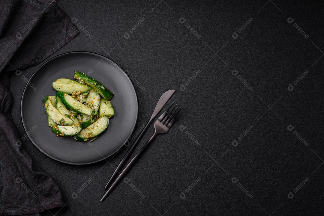 Delicioso pepino suculento cortado em grandes fatias com sal, especiarias e mostarda francesa sobre um fundo escuro de concreto