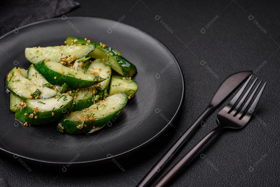 Delicioso pepino suculento cortado em grandes fatias com sal, especiarias e mostarda francesa sobre um fundo escuro de concreto