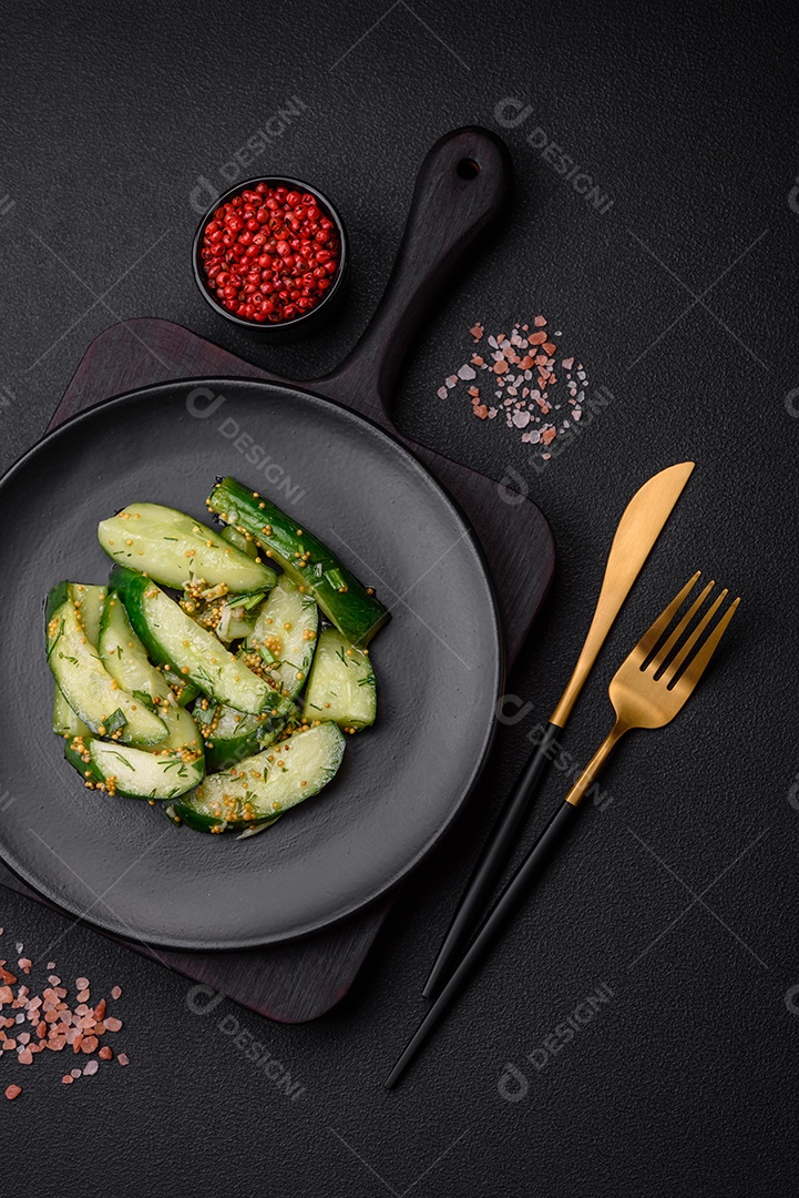 Delicioso pepino suculento cortado em grandes fatias com sal, especiarias e mostarda francesa sobre um fundo escuro de concreto