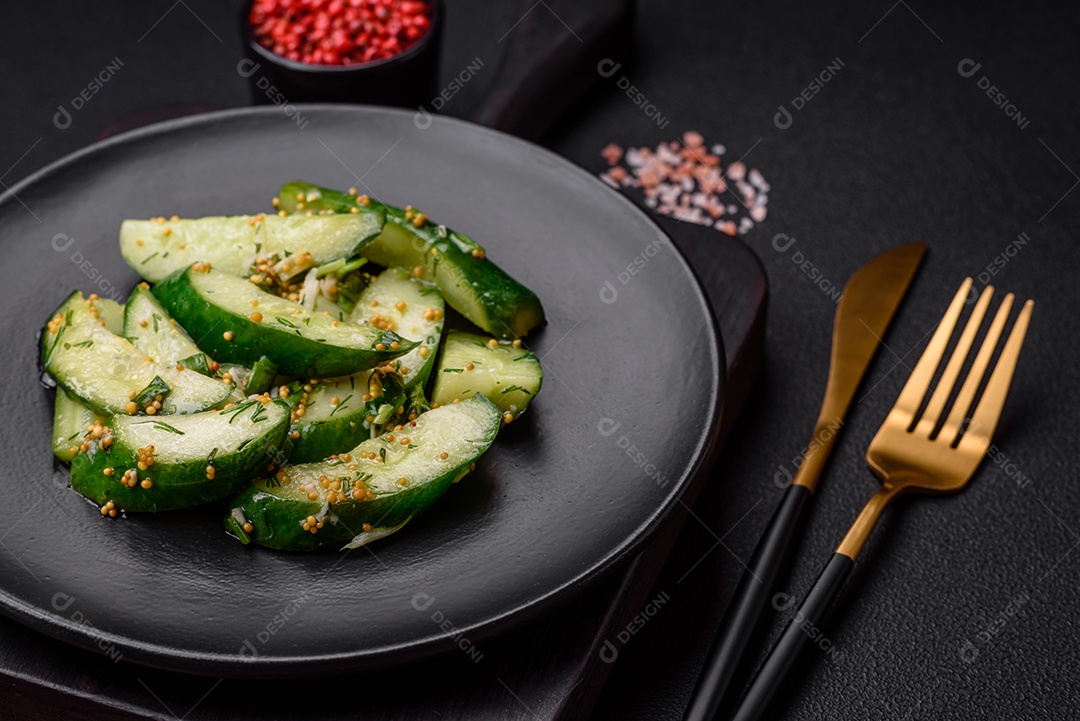 Delicioso pepino suculento cortado em grandes fatias com sal, especiarias e mostarda francesa sobre um fundo escuro de concreto