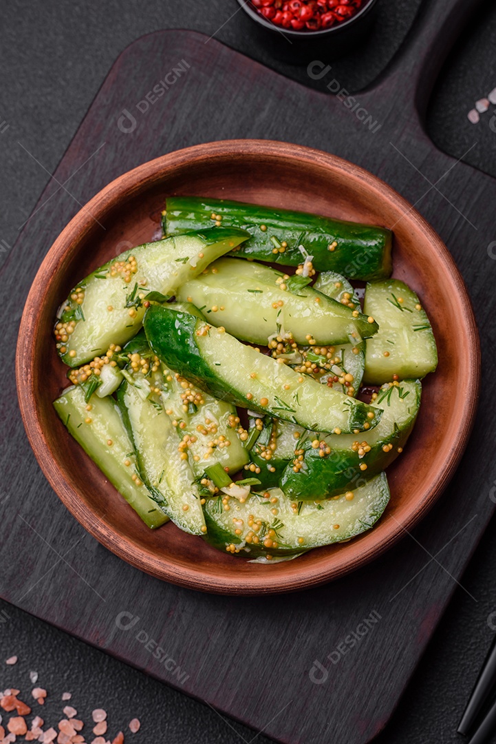 Delicioso pepino suculento cortado em grandes fatias com sal, especiarias e mostarda francesa sobre um fundo escuro de concreto
